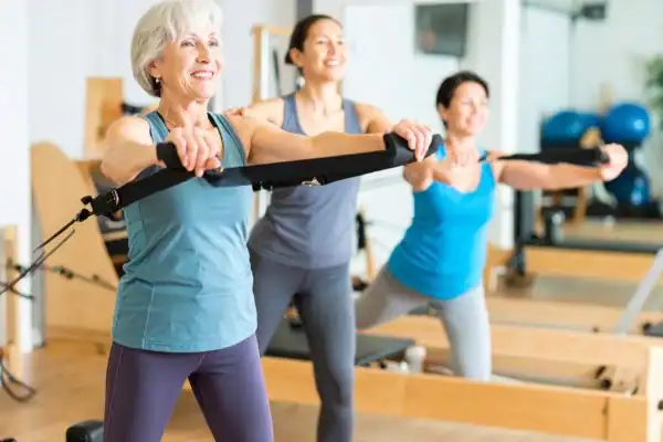 Toning Arms After 60: Empowering Womens Fitness Through Effective Weight Training 2 older woman doing weight training Hemel Hempstead and resistance in the gym to tone upper arms