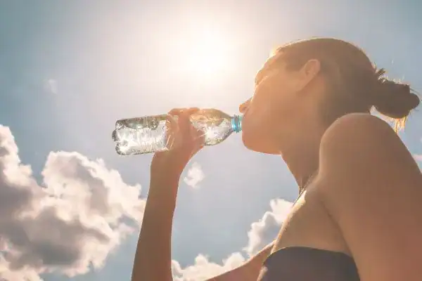 Hydration: The Secret Ingredient for a Toned Stomach and Enhanced Fitness 3 Image of woman drinking water to hydrate Hemel Hempstead after run.